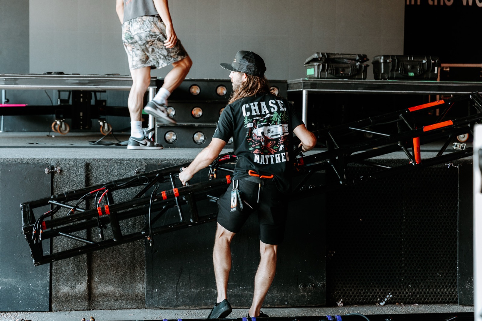 Crew lifting a lighting truss into position on the stage