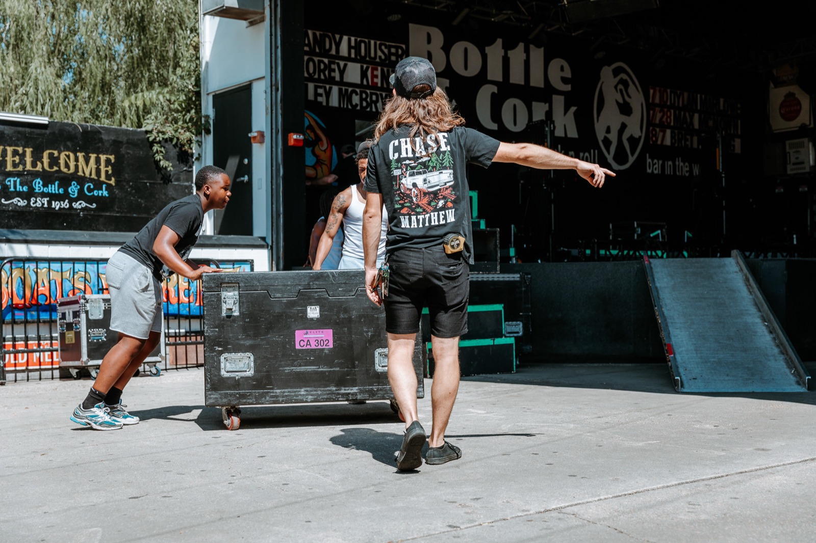 Crew wheeling a flight case into the venue at load-in