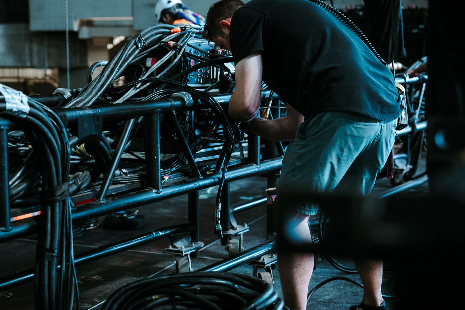 Rigger bent over stage hardware during the build