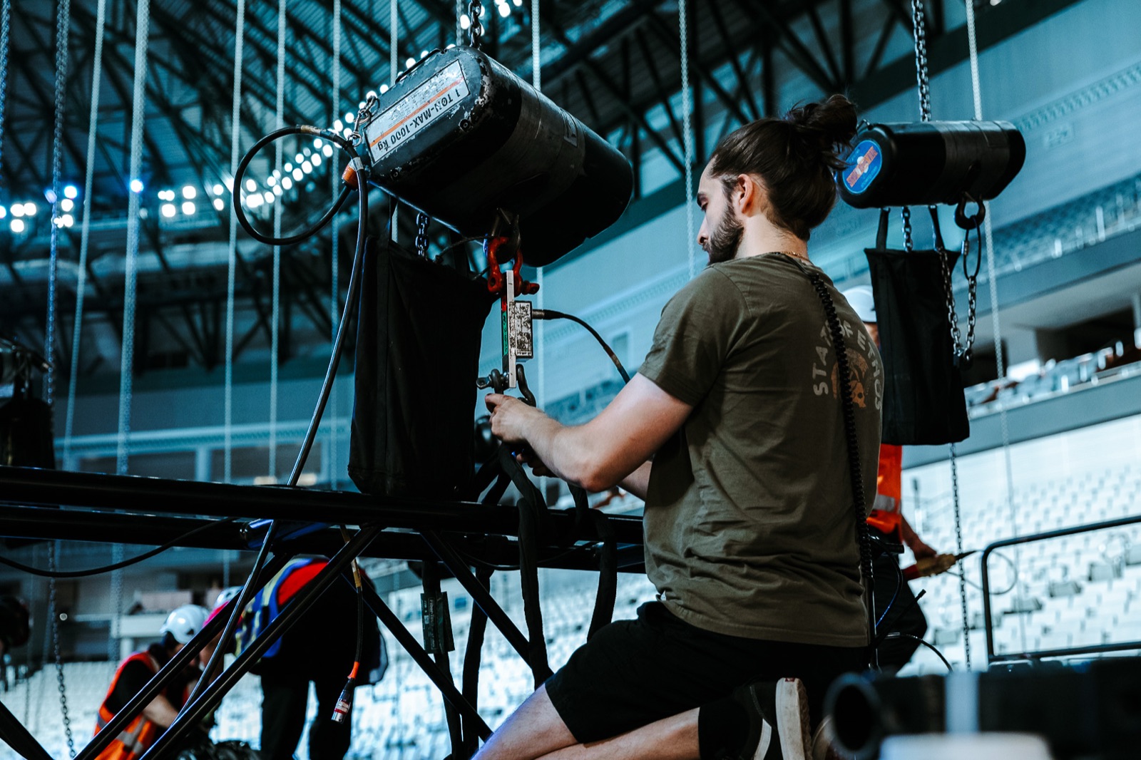 Crew member working on a flown lighting fixture during the build